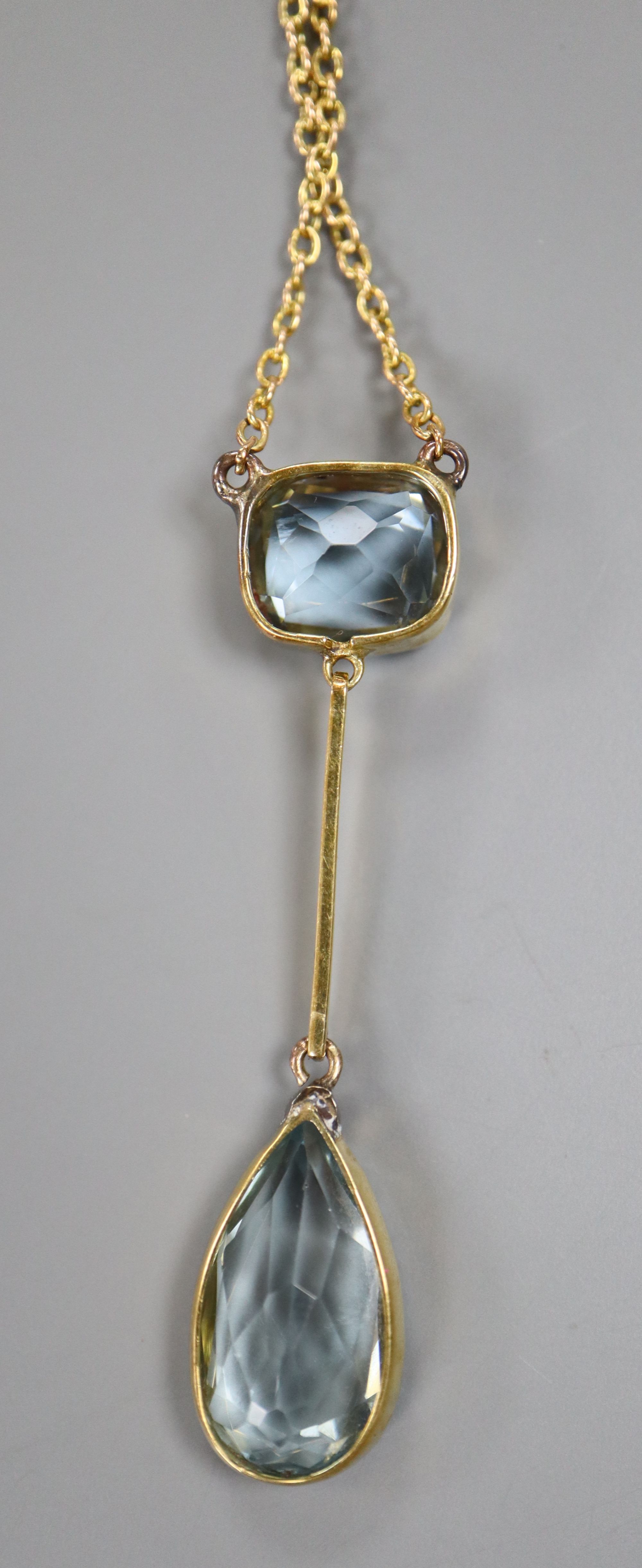 A yellow metal and two stone aquamarine drop pendant necklace, 25.5cm, gross 5.8 grams.